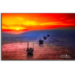 Offshore drilling as the sun sets behind a row of rigs. The Beauty of Offshore By Bob Callender